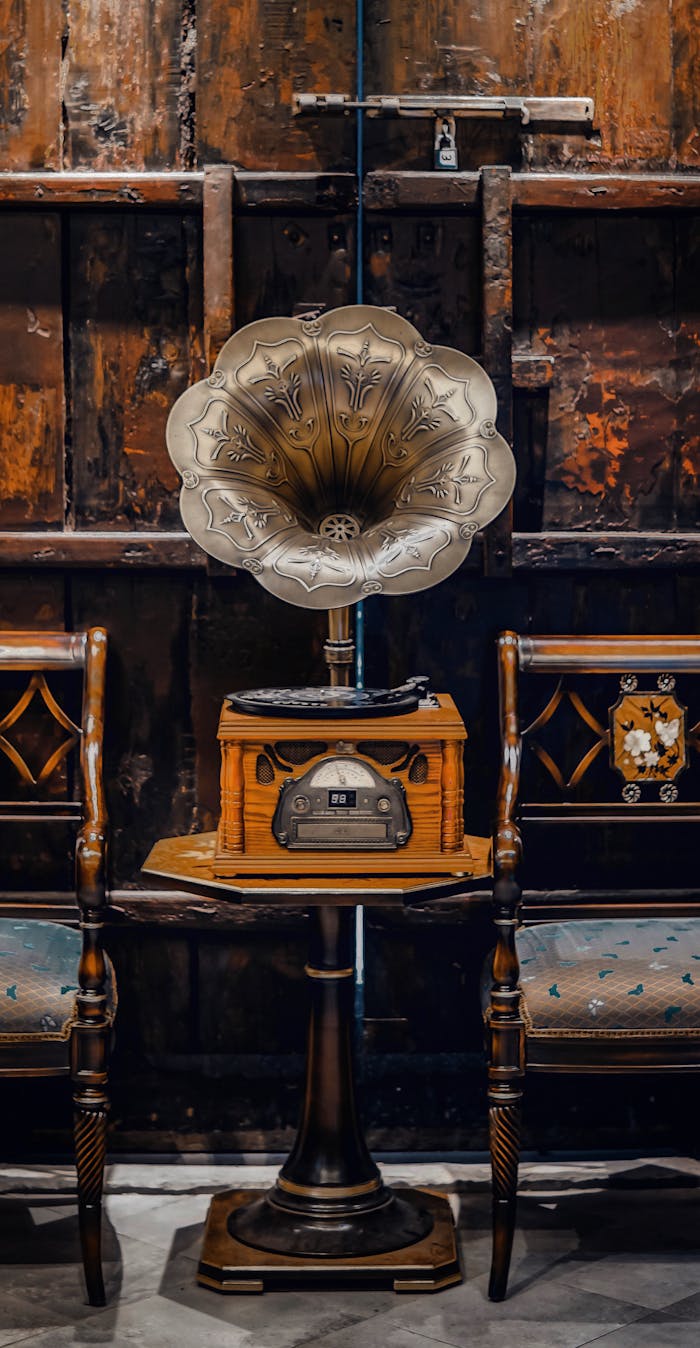A captivating vintage gramophone surrounded by classic wooden chairs in an antique setting.
